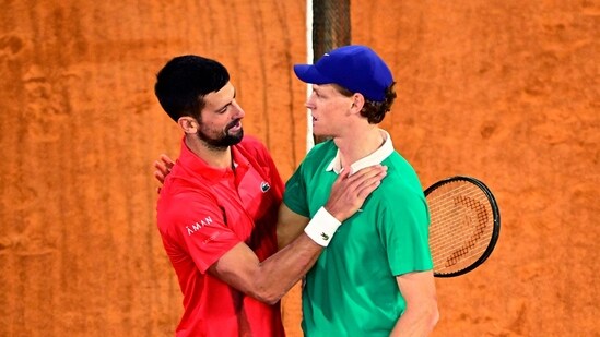 Winner Italy's Jannik Sinner cheers Serbia's Novak Djokovic (L) at the end of their men's singles semi-final match. (AFP)