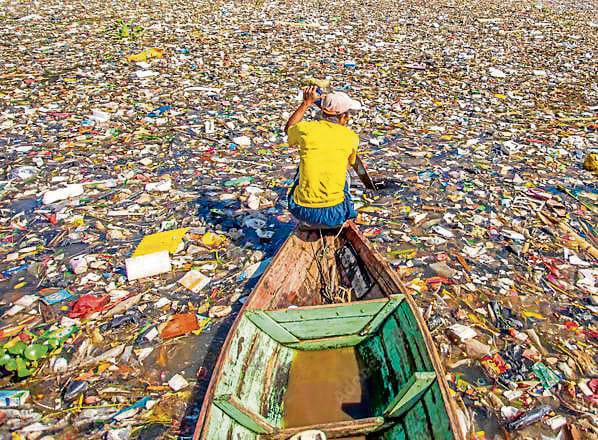Scavengers go fishing for trash on the heavily polluted Citarum river in Indonesia. (Adobe stock) Scavengers go fishing for trash on the heavily polluted Citarum river in Indonesia. (Adobe stock)