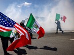 A man holds a Mexican flag during a standoff by protesters and law enforcement as immigration raids trigger LA protests. National Guard troops deployed in California,