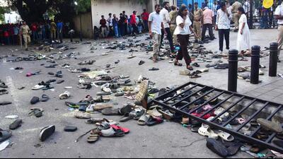 People stand next to abandoned shoes and a fallen barrier following a stampede outside the M Chinnaswamy Stadium in Bengaluru on June 4. At least 11 people were killed in a stampede; (right) At the New Delhi Railway station where a stampede broke out after a huge crowd devotees tried to board two Prayagraj-bound that arrived around the same time, in February. (AFP)