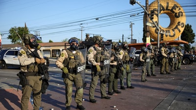 Members of law enforcement operate during a standoff between police and protesters following multiple detentions by Immigration and Customs Enforcement (ICE), in the Los Angeles County city of Compton, California. (REUTERS)