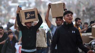 People carry relief supplies from the Gaza Humanitarian Foundation (GHF), a private US-backed aid group that has bypassed the longstanding UN-led system in the territory (AFP) People carry relief supplies from the Gaza Humanitarian Foundation (GHF), a private US-backed aid group that has bypassed the longstanding UN-led system in the territory (AFP)