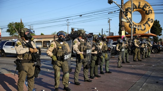 Members of law enforcement operate during a standoff between police and protesters following multiple detentions by Immigration and Customs Enforcement (ICE), in the Los Angeles County city of Compton, California.(REUTERS)
