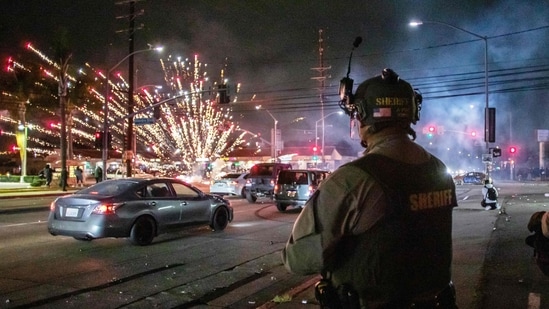 Amid protests over immigration raids, National Guard troops arrived in Los Angeles early Sunday, ordered by President Trump, overriding Governor Gavin Newsom’s objections. In pic: A firework sent by protesters explodes near by the Los Angeles Sheriff Department officers during immigration protest on June 7, 2025.&nbsp;(AFP)