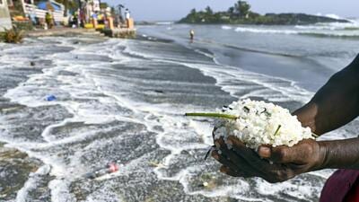 A man shows plastic pellets, that have been washing ashore ever since a Liberian-flagged container ship MSC ELSA 3 sank off the Kerala coast, on ‘World Environment Day’, at Kovalam beach, in Thiruvananthapuram, Thursday, June 5. (PTI)