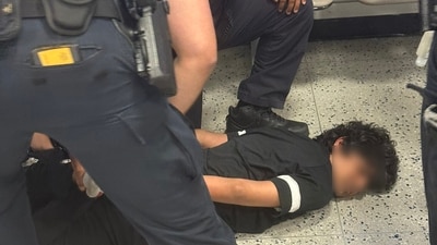 An Indian man was handcuffed and pinned to the ground at USA's Newark Airport (X/@SONOFINDIA) An Indian man was handcuffed and pinned to the ground at USA's Newark Airport (X/@SONOFINDIA)