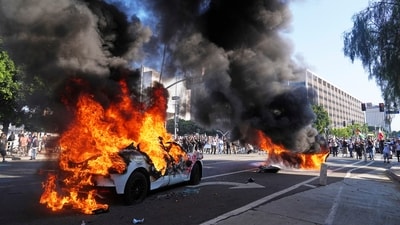 Two Waymo taxis burn near the metropolitan detention center of downtown Los Angeles, Sunday, June 8, 2025, following last night's immigration raid protest. (AP) Two Waymo taxis burn near the metropolitan detention center of downtown Los Angeles, Sunday, June 8, 2025, following last night's immigration raid protest. (AP)