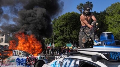 Protesters vandalise and set fire to Waymo taxis near the Metropolitan Detention Center after immigration raid protests. (AP)