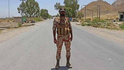 A security personnel stands guard along a street near the site of a school bus bombing in the Khuzdar district of Balochistan province on May 21, 2025. (AFP) A security personnel stands guard along a street near the site of a school bus bombing in the Khuzdar district of Balochistan province on May 21, 2025. (AFP)