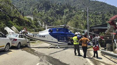 People gather near a Kedarnath Dham-bound helicopter after it made an emergency landing at Badasu area, in Rudraprayag district on June 7 (PTI) People gather near a Kedarnath Dham-bound helicopter after it made an emergency landing at Badasu area, in Rudraprayag district on June 7 (PTI)