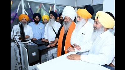 SGPC president Harjinder SIngh Dhami among others inaugurating a machine for printing of Guru Granth Sahib's holy saroops in Amritsar on Monday. (HT photo)
