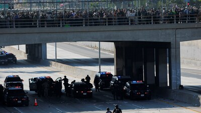 A demonstrator is detained by police during protests against federal immigration sweeps in downtown Los Angeles. (REUTERS)