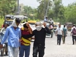 People seen covering their head and face to protect themselves from heatwave in Gurugram on Monday, June 9.