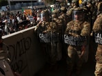 Members of the California National Guard stand in a line, blocking an entrance to the Federal Building, as demonstrators gather nearby, during protests against immigration sweeps, in Los Angeles, California, U.S. June 9, 2025. (REUTERS/Leah Millis)