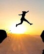 Woman jumping over abyss in fornt of sunset. (Getty Images/iStockphoto)