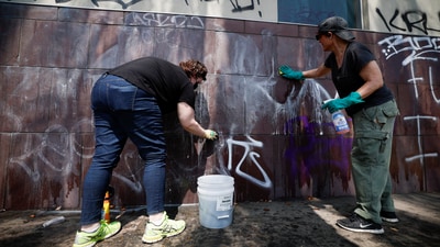 Social activists and artists take graffiti off from the Japanese American National Museum (REUTERS)