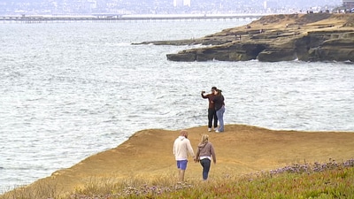 This image taken from video provided by KGTV shows people on a cliff near where a twin-engine Cessna 414 crashed on Sunday, June 8, 2025, leaving a debris field about 3 miles west of Point Loma, a San Diego neighborhood that juts into the Pacific. (KGTV via AP) (AP) This image taken from video provided by KGTV shows people on a cliff near where a twin-engine Cessna 414 crashed on Sunday, June 8, 2025, leaving a debris field about 3 miles west of Point Loma, a San Diego neighborhood that juts into the Pacific. (KGTV via AP) (AP)