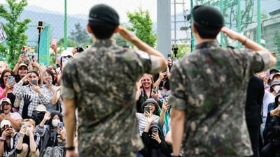 Fans react as K-pop boy band BTS members RM (foreground R) and V salute toward them at an outdoor sporting facility in Chuncheon on June 10, 2025, after their release from 18 months of South Korean military service. Hundreds of fans gathered near two army bases just outside of the capital Seoul where band leader RM -- recently named "Favorite K-pop Artist" at the American Music Awards -- and singer V were discharged. (AFP) Fans react as K-pop boy band BTS members RM (foreground R) and V salute toward them at an outdoor sporting facility in Chuncheon on June 10, 2025, after their release from 18 months of South Korean military service. Hundreds of fans gathered near two army bases just outside of the capital Seoul where band leader RM -- recently named "Favorite K-pop Artist" at the American Music Awards -- and singer V were discharged. (AFP)
