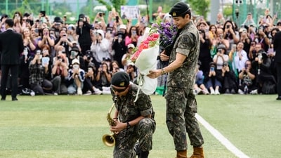 K-pop boy band BTS members RM (L) plays the saxophone while V looks on while holding flower bouquets at an outdoor sporting facility in Chuncheon on June 10, 2025, after their release from 18 months of South Korean military service. Hundreds of fans gathered near two army bases just outside of the capital Seoul where band leader RM -- recently named "Favorite K-pop Artist" at the American Music Awards -- and singer V were discharged (AFP) K-pop boy band BTS members RM (L) plays the saxophone while V looks on while holding flower bouquets at an outdoor sporting facility in Chuncheon on June 10, 2025, after their release from 18 months of South Korean military service. Hundreds of fans gathered near two army bases just outside of the capital Seoul where band leader RM -- recently named "Favorite K-pop Artist" at the American Music Awards -- and singer V were discharged (AFP)