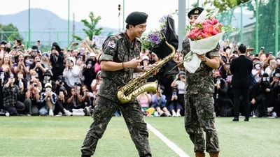 K-pop boy band BTS members RM (L) smiles while holding a saxophone while V looks on while holding flower bouquets at an outdoor sporting facility in Chuncheon on June 10, 2025, after their release from 18 months of South Korean military service. Hundreds of fans gathered near two army bases just outside of the capital Seoul where band leader RM -- recently named "Favorite K-pop Artist" at the American Music Awards -- and singer V were discharged. (AFP) K-pop boy band BTS members RM (L) smiles while holding a saxophone while V looks on while holding flower bouquets at an outdoor sporting facility in Chuncheon on June 10, 2025, after their release from 18 months of South Korean military service. Hundreds of fans gathered near two army bases just outside of the capital Seoul where band leader RM -- recently named "Favorite K-pop Artist" at the American Music Awards -- and singer V were discharged. (AFP)