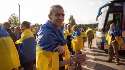 A Ukrainian prisoner of war (POW), wrapped with a Ukrainian national flag, looks on following an exchange at an undisclosed location, amid the Russian invasion in Ukraine (AFP) A Ukrainian prisoner of war (POW), wrapped with a Ukrainian national flag, looks on following an exchange at an undisclosed location, amid the Russian invasion in Ukraine (AFP)