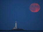 The full moon, also known as the Strawberry Moon, spotted over St Mary's Lighthouse in Whitley Bay, England The full moon, also known as the Strawberry Moon, spotted over St Mary's Lighthouse in Whitley Bay, England