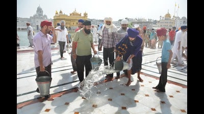 Devotees put water on the floor on a hot summer day at Golden Temple in Amritsar on Wednesday. (Sameer Sehgal/HT) Devotees put water on the floor on a hot summer day at Golden Temple in Amritsar on Wednesday. (Sameer Sehgal/HT)