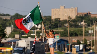 The protests continued on Tuesday in other parts of the US as well. In this photo, Brila Adauto of Omaha waves a Mexican flag as hundreds gather in after US ICE conducted a raid earlier in the day in Omaha on Tuesday. (AP) The protests continued on Tuesday in other parts of the US as well. In this photo, Brila Adauto of Omaha waves a Mexican flag as hundreds gather in after US ICE conducted a raid earlier in the day in Omaha on Tuesday. (AP)
