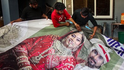 Indore: Family members of Raja Raghuvanshi, who was murdered during his honeymoon in Meghalaya, cut out the picture of his wife Sonam Raghuvanshi from a poster. (PTI) Indore: Family members of Raja Raghuvanshi, who was murdered during his honeymoon in Meghalaya, cut out the picture of his wife Sonam Raghuvanshi from a poster. (PTI)