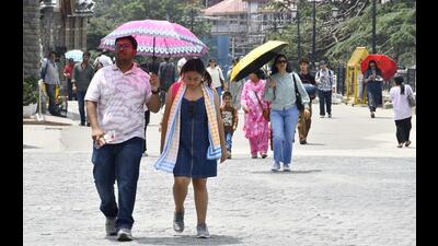 People walking under umbrellas to protect themselves from scorching heat on The Ridge in Shimla on Wednesday. (HT Photo) People walking under umbrellas to protect themselves from scorching heat on The Ridge in Shimla on Wednesday. (HT Photo)