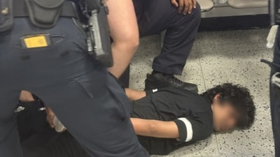The youth was wrestled to the ground and handcuffed. (X) The youth was wrestled to the ground and handcuffed. (X)