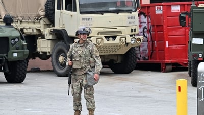 A member of the California National Guard stands guard outside federal buildings in Los Angeles. (AFP) A member of the California National Guard stands guard outside federal buildings in Los Angeles. (AFP)