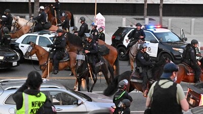 Mounted Police moves on to clear the street as an overnight curfew went into effect in protest-hit downtown Los Angeles on June 10. (AFP) Mounted Police moves on to clear the street as an overnight curfew went into effect in protest-hit downtown Los Angeles on June 10. (AFP)