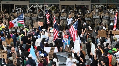 California National Guard and US Customs and Border Protection watch demonstrators gather in front the Federal Building before curfew goes in effect following days of protests in response to federal immigration operations in Los Angeles on June 10, 2025. (AFP) California National Guard and US Customs and Border Protection watch demonstrators gather in front the Federal Building before curfew goes in effect following days of protests in response to federal immigration operations in Los Angeles on June 10, 2025. (AFP)
