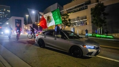 Demonstrators in a car and on bikes are seen in downtown despite a curfew that was put into effect following days of protests in Los Angeles (AFP) Demonstrators in a car and on bikes are seen in downtown despite a curfew that was put into effect following days of protests in Los Angeles (AFP)
