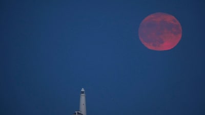 The full moon, also known as the Strawberry Moon, spotted over St Mary's Lighthouse in Whitley Bay, England (AP) The full moon, also known as the Strawberry Moon, spotted over St Mary's Lighthouse in Whitley Bay, England (AP)