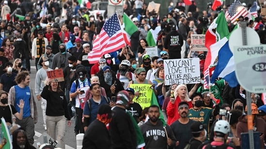 Demonstrators march in front of the Federal Building before the curfew imposed by LA Mayor Karen Bass goes into effect.(AFP)