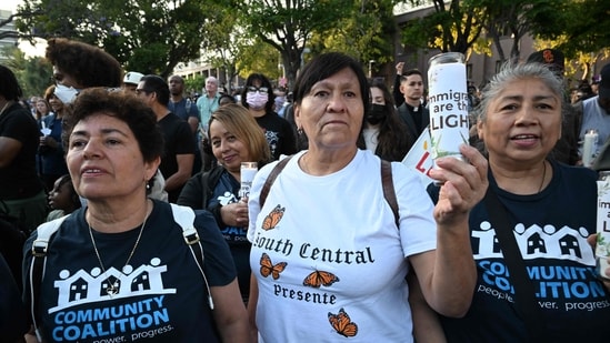 A woman holds a candle with the words ‘Immigrants are the Light’ during a prayer vigil before curfew goes in effect following days of protests in Los Angeles on June 10, 2025.&nbsp;(AFP)