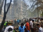Emergency personnel and other people gather near damaged property at the site where an Air India plane crashed in Ahmedabad on June 12, 2025.