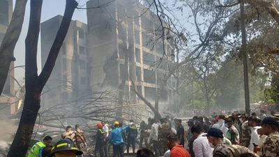 Emergency personnel and other people gather near damaged property at the site where an Air India plane crashed in Ahmedabad on June 12, 2025. (Reuters)