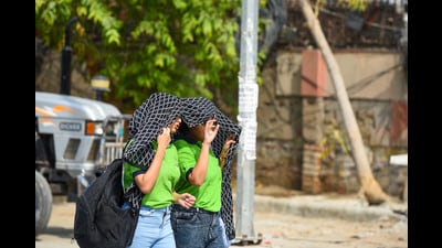 Girls cover themselves with a cloth on a hot summer day in the city at MG road near Mahavir Park in Gurugram on Thursday. (Parveen Kumar/HT)