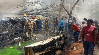 Emergency personnel and other people gather near damaged property at the site where an Air India plane crashed in Ahmedabad on June 12, 2025. (REUTERS)