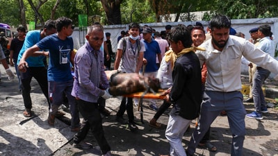 An injured man being taken for treatment. Prime Minister Narendra Modi spoke to Union Home Minister Amit Shah and Civil Aviation Minister Ram Mohan Naidu, asking them to go to Ahmedabad and ensure all possible assistance to those affected in the tragedy, sources said. (PTI) An injured man being taken for treatment. Prime Minister Narendra Modi spoke to Union Home Minister Amit Shah and Civil Aviation Minister Ram Mohan Naidu, asking them to go to Ahmedabad and ensure all possible assistance to those affected in the tragedy, sources said. (PTI)
