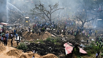 People gather near the debris of the crashed Air India plane in Ahmedabad on Thursday. (PTI) People gather near the debris of the crashed Air India plane in Ahmedabad on Thursday. (PTI)