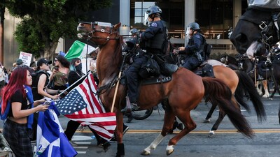 Mounted law enforcement officers confront demonstrators, as they march through downtown as part of the ongoing protests against Immigration and Customs Enforcement (ICE). (Reuters)