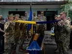 Ukrainian soldiers unwrap the Ukrainian national flag over the coffin of a 21-year-old Ukrainian serviceman who was killed in the battle near the Zaporizhzhia direction, during the funeral ceremony in Kyiv on June 2, 2025.