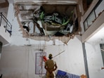 A police officer stands in front of debris at the crash site after an Air India aircraft, bound for London's Gatwick Airport, crashed during take-off from an airport in Ahmedabad.