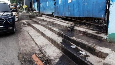 Fencing wall collapse of garbage processing facility located near Katraj Dairy and waste spilling onto main road pose health risk, inconvenience commuters and residents. (MAHENDRA KOLHE/HT)