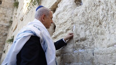 Prime Minister Benjamin Netanyahu was photographed on Thursday putting a handwritten note into a crack of Jerusalem's Western Wall, Judaism's holiest prayer site. (AFP)