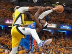 Oklahoma City Thunder guard Luguentz Dort, right, tries to shoot over Indiana Pacers center Myles Turner during the second half of Game 4 of the NBA Finals basketball series, Friday, June 13, 2025, in Indianapolis. (AP Photo/Michael Conroy)